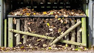 a messy organic compost bin made of wood full of leaves and sticks and debris that is slowly turning into dirt-1